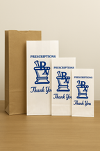 Three white bags with blue 'Prescriptions Thank You' text and a brown paper bag on a beige background